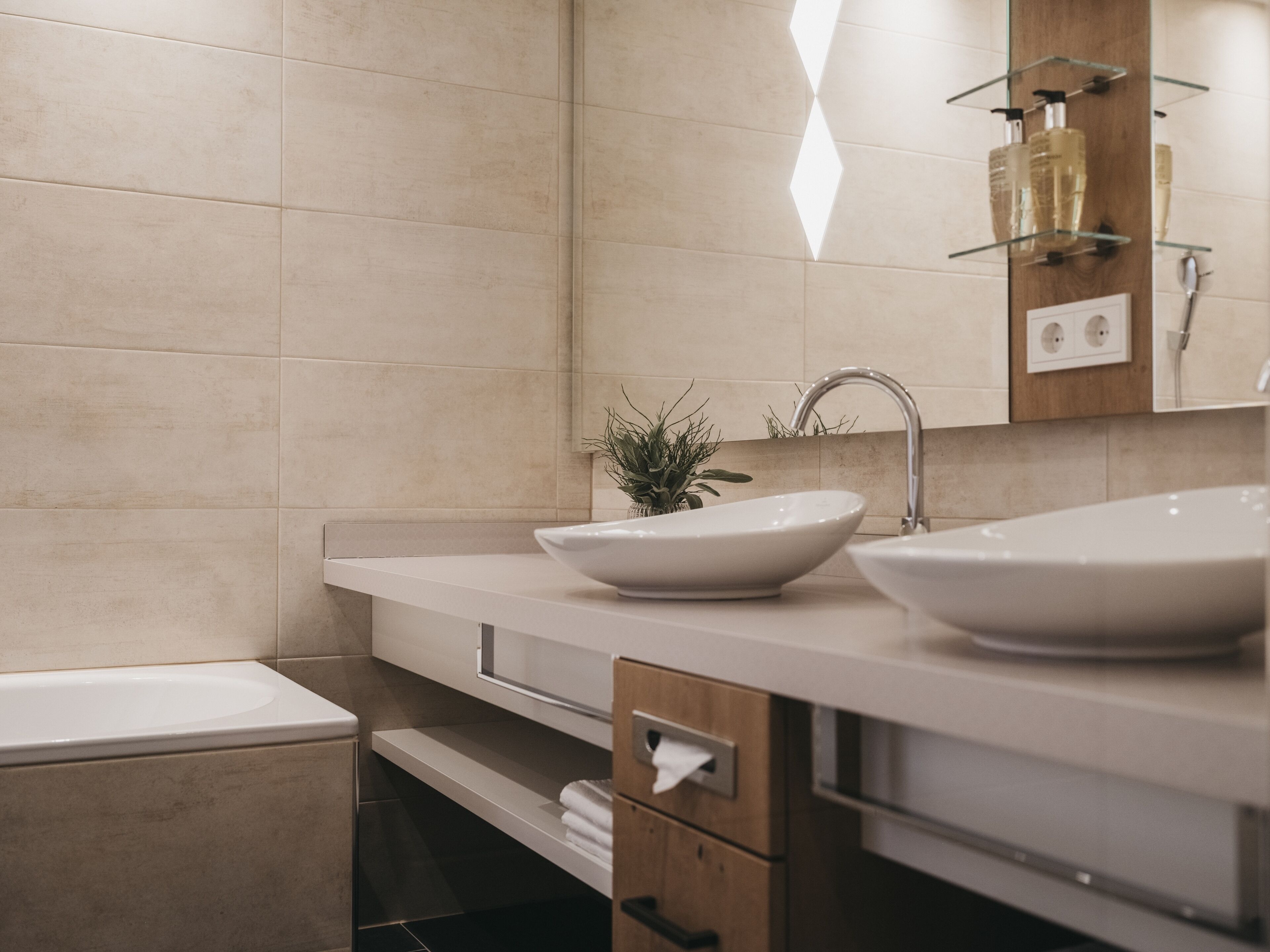 Une salle de bain moderne avec deux lavabos, un miroir et un porte-serviettes.