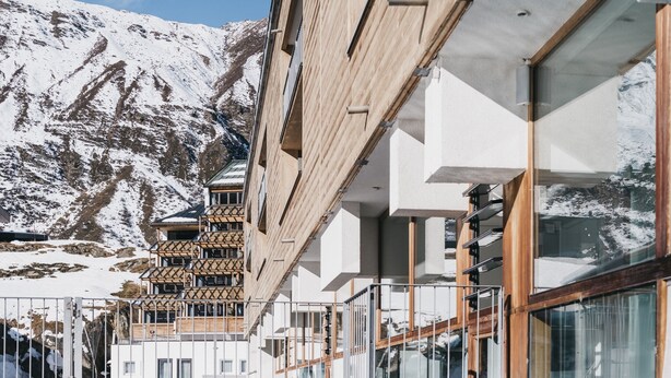A modern building with a pool reflecting the surrounding mountains. - The Crystal VAYA Unique (Obergurgl)