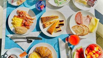 A breakfast spread on a table with various food items and drinks.
