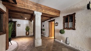 Un pasillo con suelo de piedra, vigas de madera y un estilo rústico.
