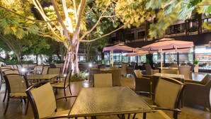 An outdoor dining area with tables and chairs, surrounded by trees and umbrellas. - The Greenery Resort Khao Yai (Pak Chong)