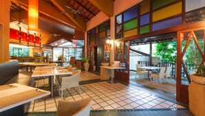 A restaurant with outdoor seating, a tiled floor, and large windows with colorful glass panes. - The Greenery Resort Khao Yai (Pak Chong)