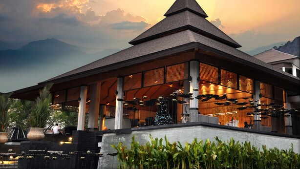 A modern building with a pyramid-shaped roof, large windows, and a balcony with plants. - The Greenery Resort Khao Yai (Pak Chong)