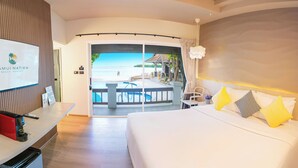 Une chambre d’hôtel comprenant un lit, un bureau avec une machine à café, un téléviseur affichant le nom de l’hôtel et un balcon avec vue sur la piscine.