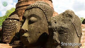 A stone Buddha head sculpture with a detailed headdress, set against a brick structure. - Sunday Ayothaya Hotel (Ayutthaya)