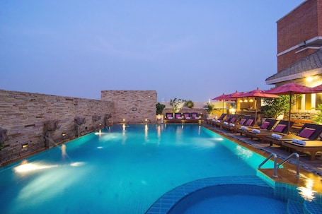 Una piscina al aire libre, sillones reclinables de piscina