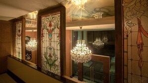 A grand staircase with ornate stained glass panels and crystal chandeliers. - Hope Land Executive Serviced Apartment (Bangkok)