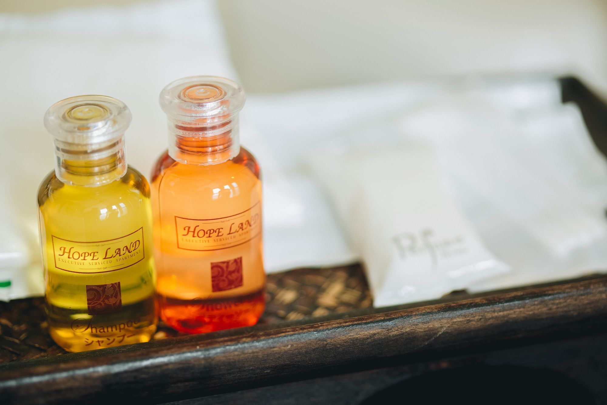 Two bottles of Hope Land shampoo and conditioner on a wooden surface.