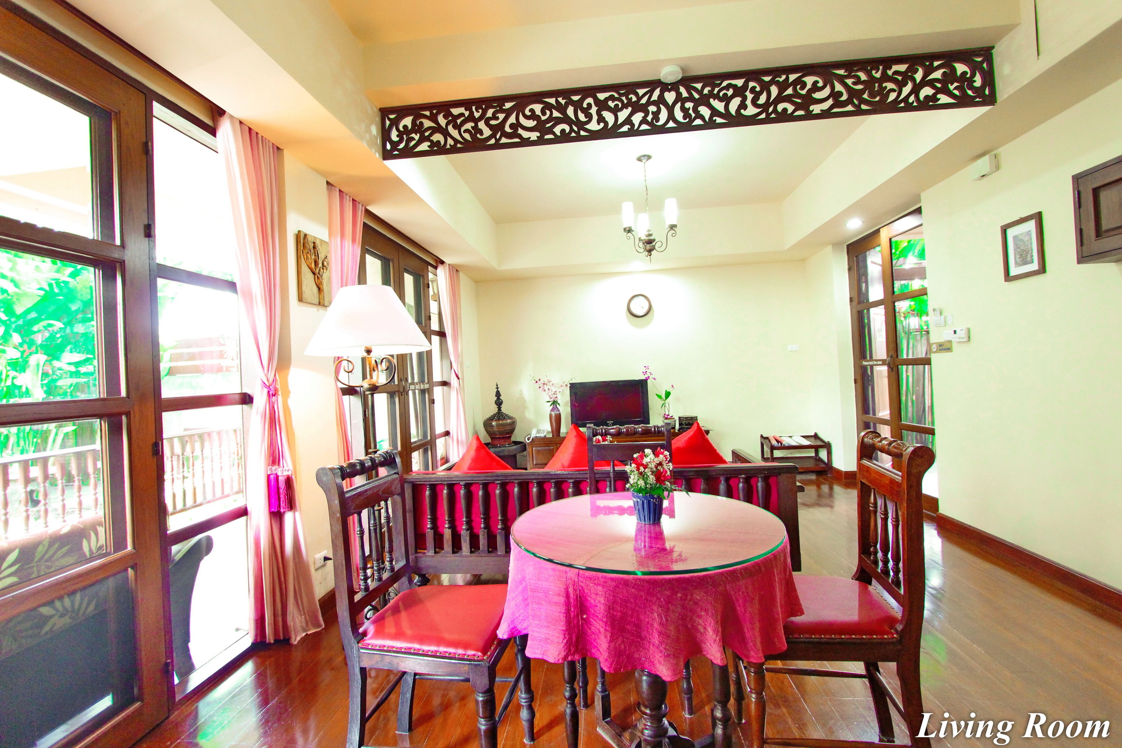 A dining area with a round table, chairs, and a chandelier.