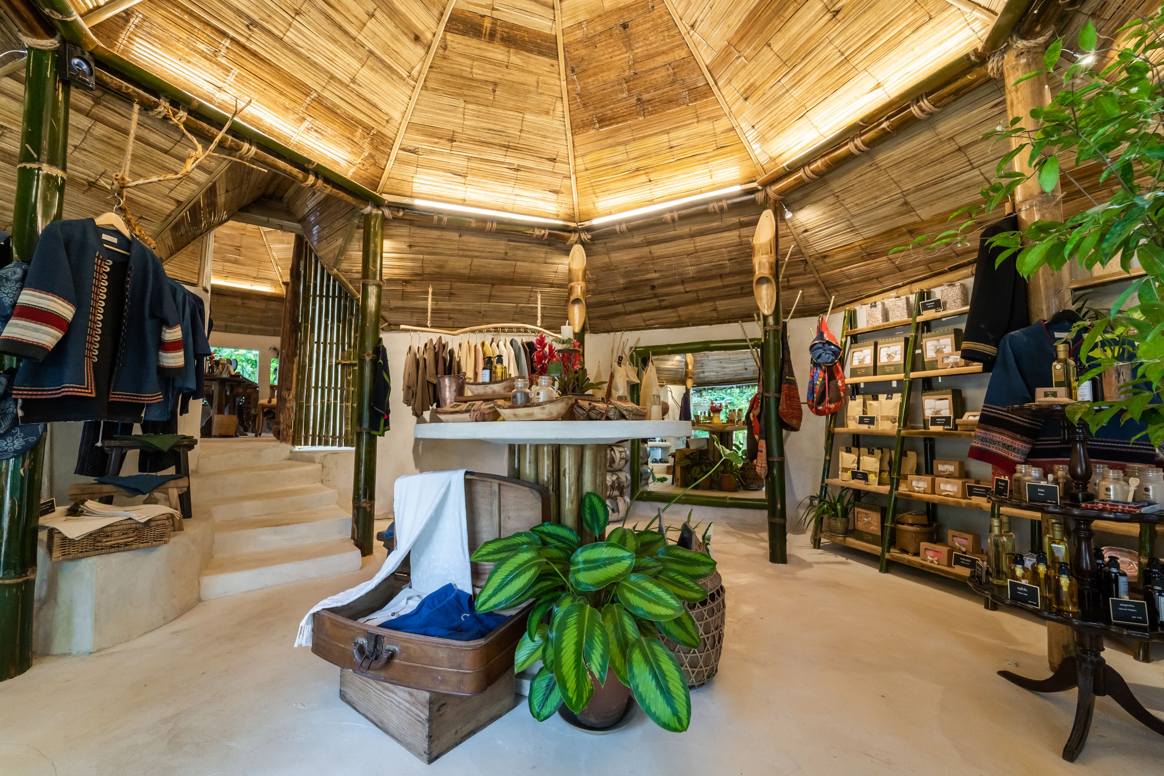 A boutique hotel interior with a bamboo ceiling, wooden furniture, and various items for sale.