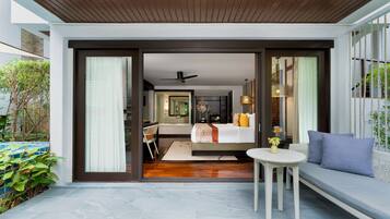 A modern hotel room with a bed, a small table, and a sofa.