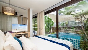 A bedroom with a large bed, a television, and a view of a swimming pool. - The Rock Hua Hin Beachfront Spa Resort (Hua Hin)