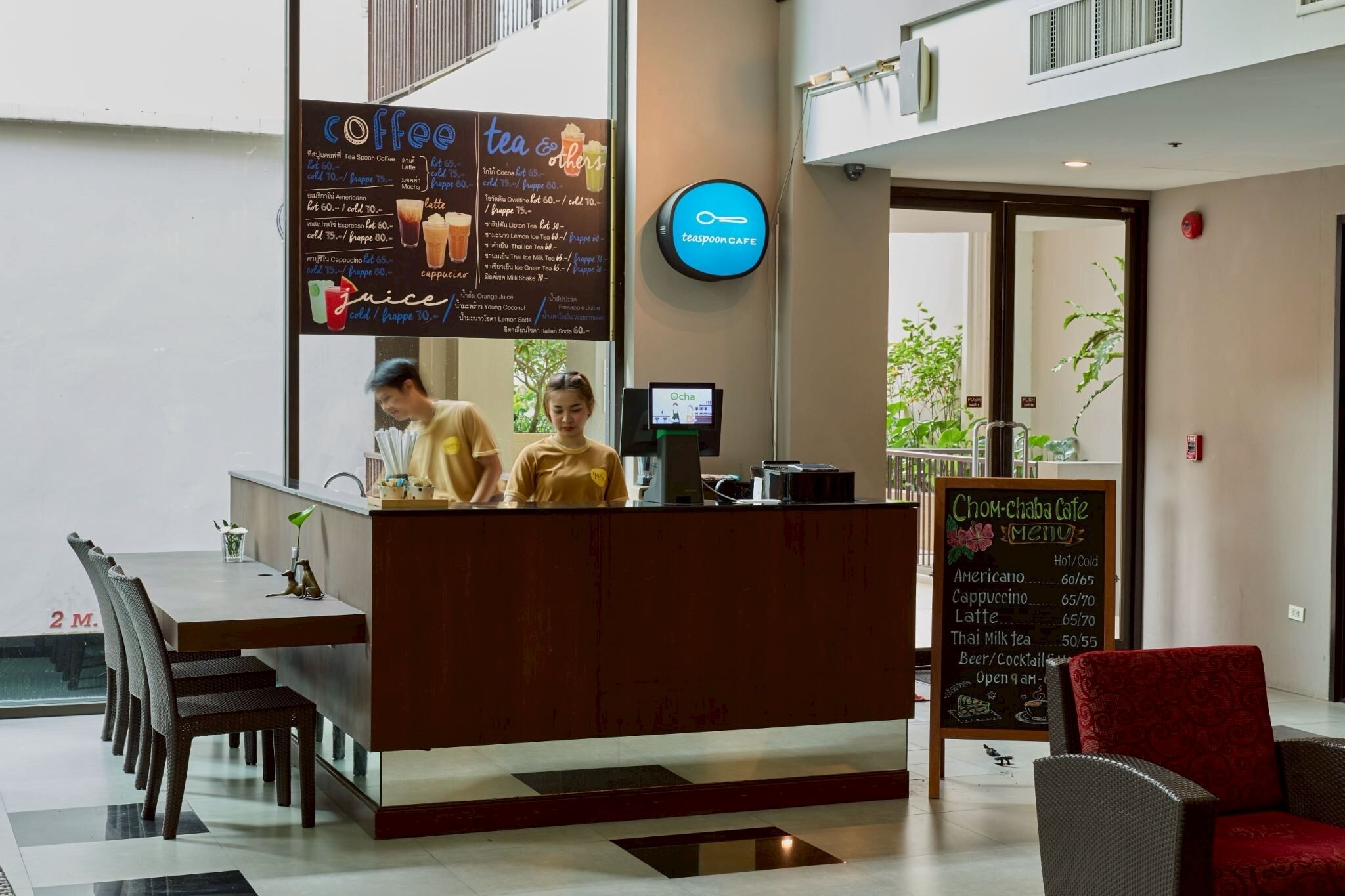A cafe with a counter, menu boards, and seating area.