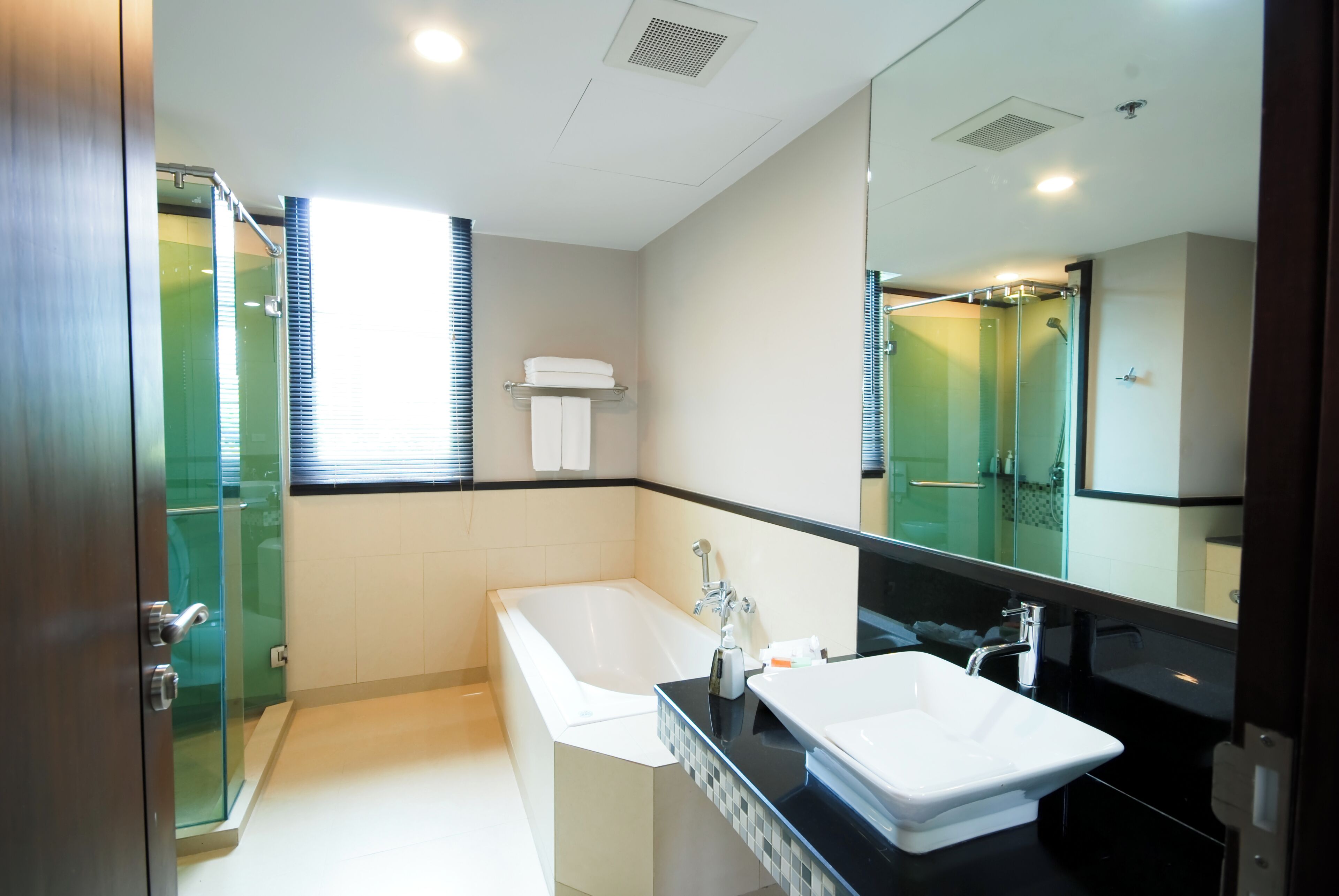 A modern bathroom with a bathtub, a sink, and a glass shower enclosure.