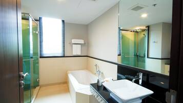 A modern bathroom with a bathtub, a sink, and a glass shower enclosure.