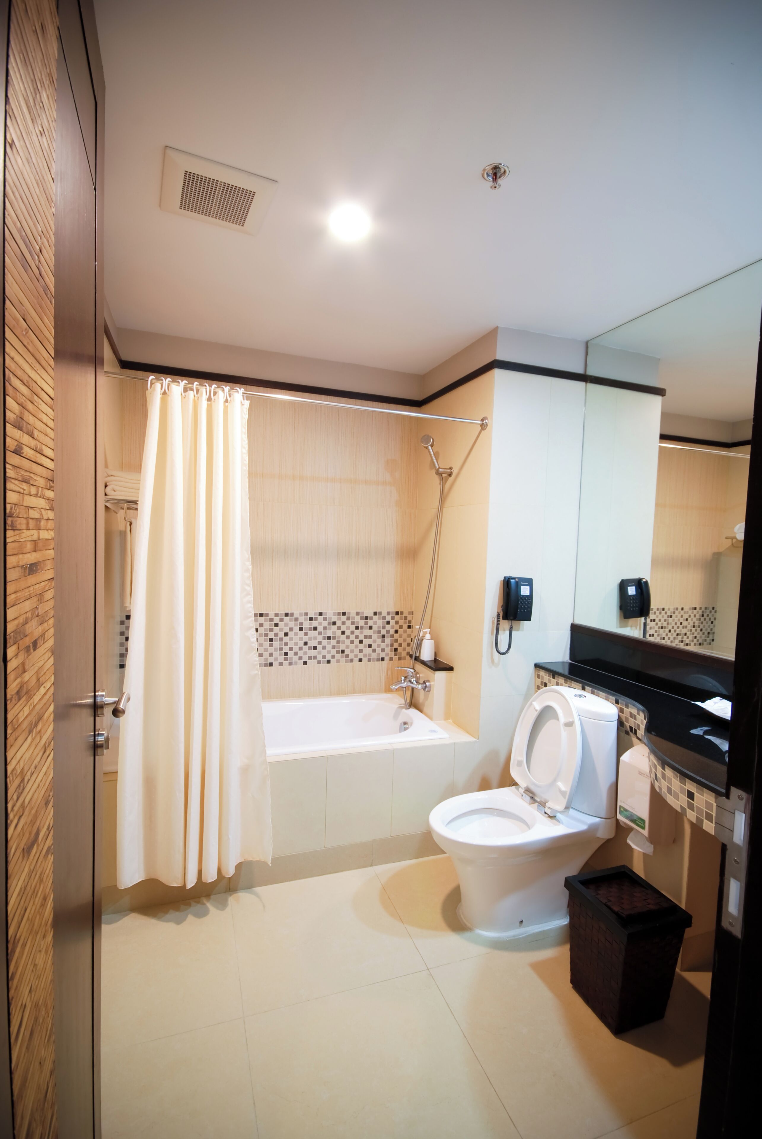 A modern bathroom with a bathtub, toilet, and shower.