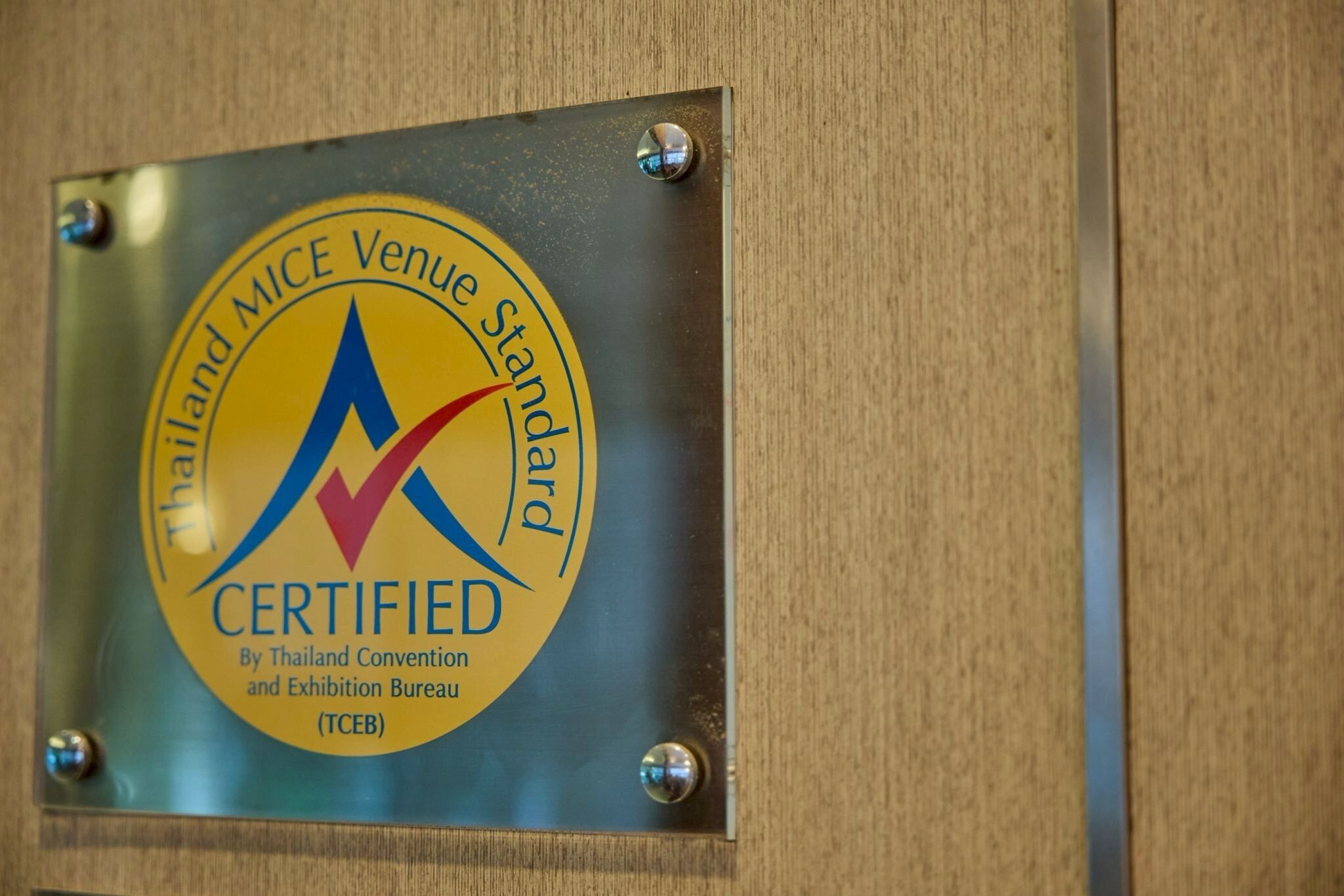 A metal plaque with a certification logo and text.