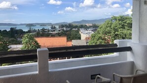 Un balcon donnant sur une ville côtière, des bâtiments et une étendue d’eau.