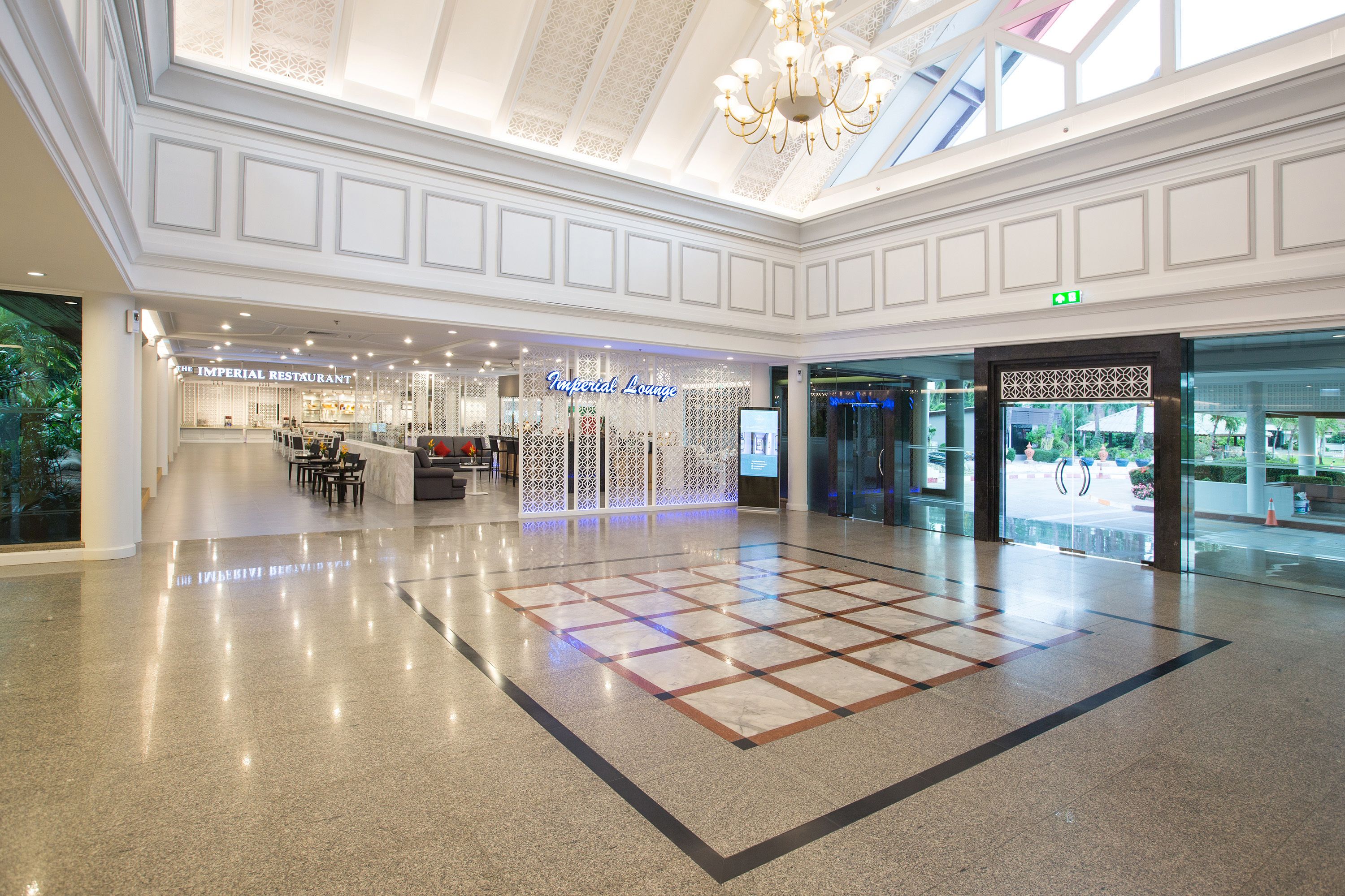 A spacious atrium with a high ceiling, a chandelier, and a central seating area.