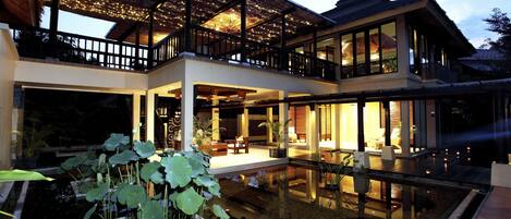Una casa moderna con un amplio patio, piscina y espacios interiores bien iluminados.