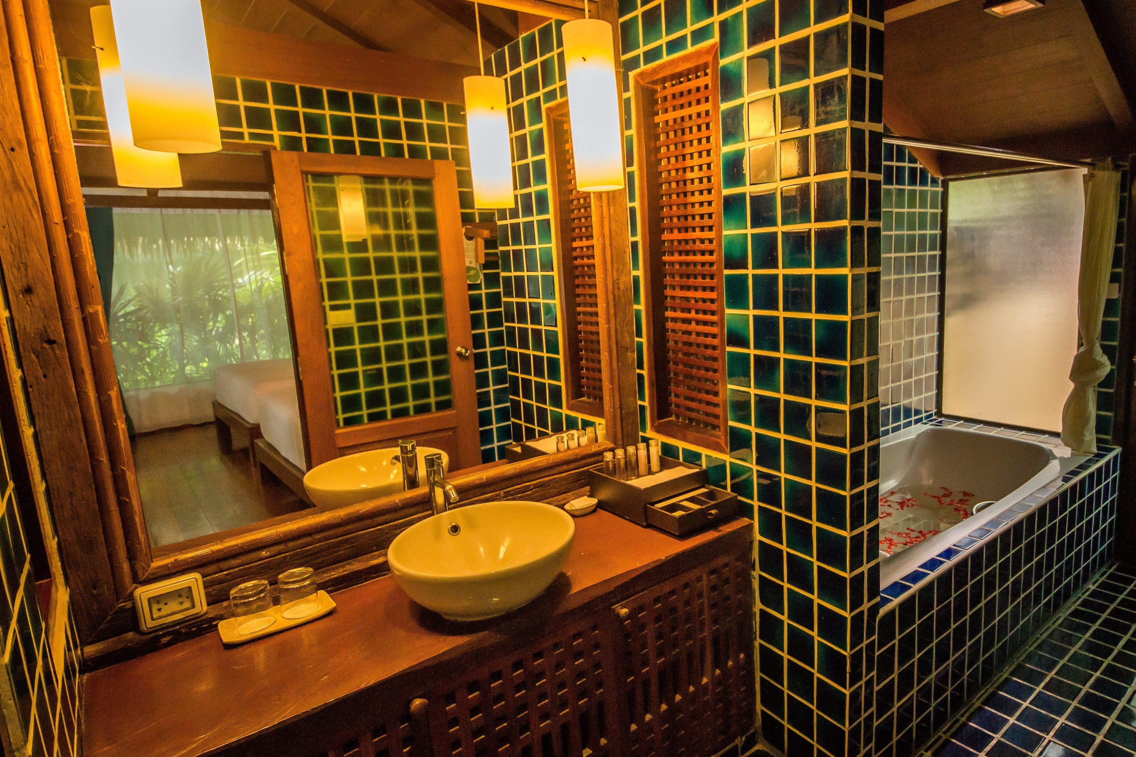 A bathroom with a wooden vanity, a large mirror, a sink, and a bathtub.