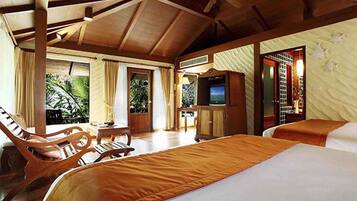 A spacious bedroom with a large bed, wooden furniture, a television, and a view of the outdoors.
