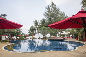 Relax by the serene pool surrounded by lush greenery and comfortable seating options.