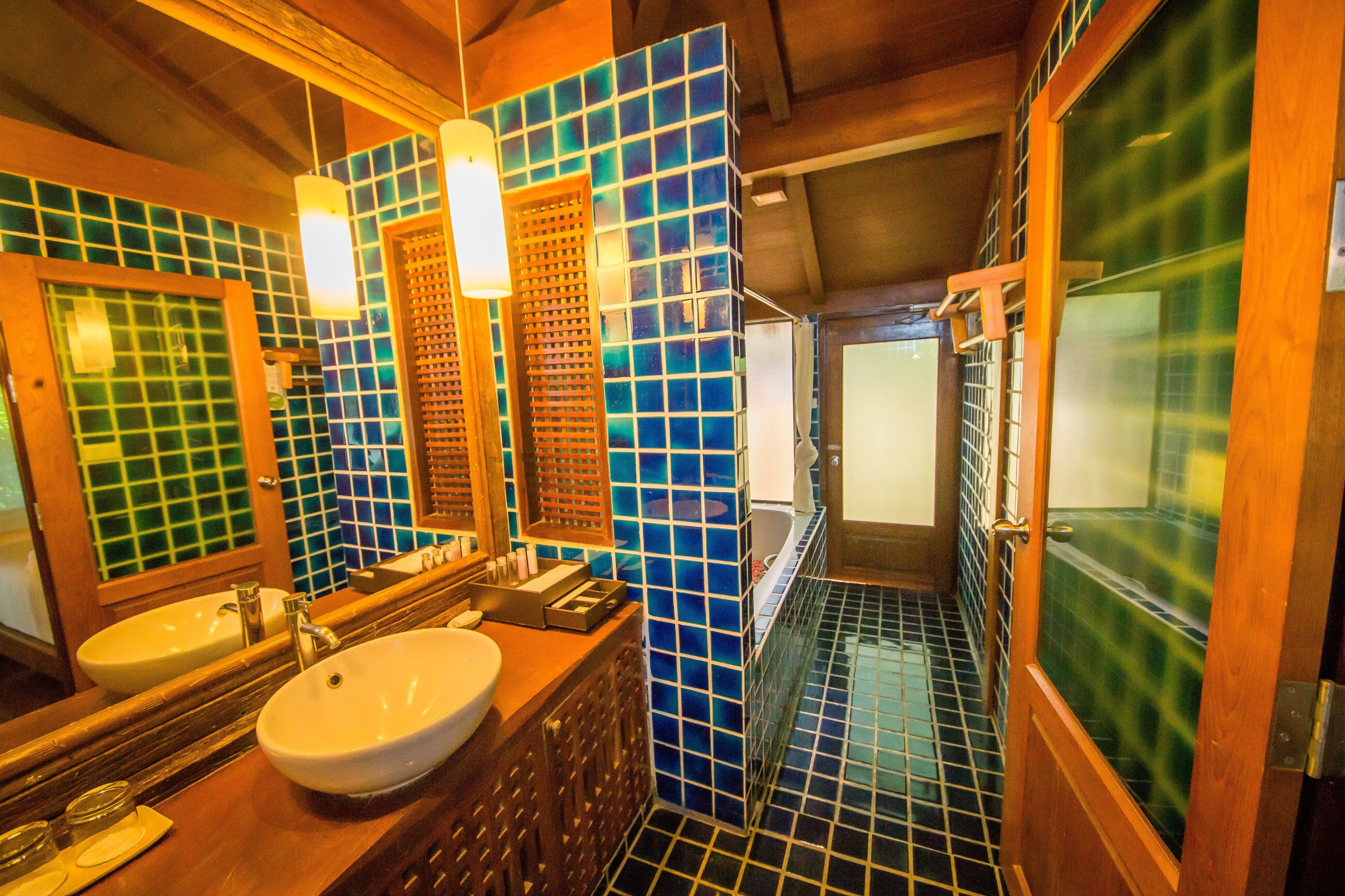 A bathroom with two sinks, a mirror, and a bathtub.