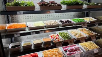 A buffet with various food options including salads, vegetables, and desserts.