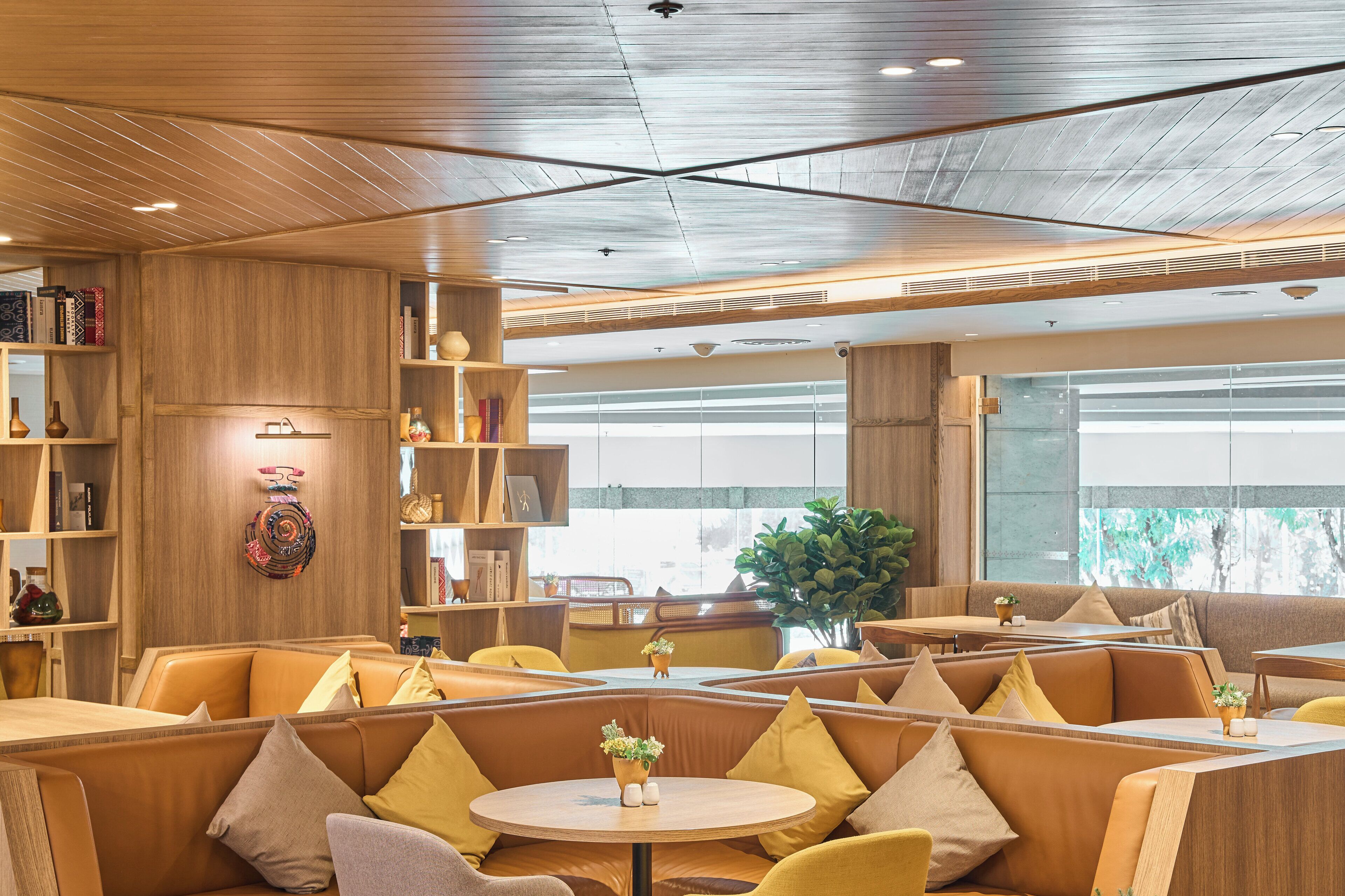 A modern interior with wooden paneling, seating areas, and a large window providing natural light.