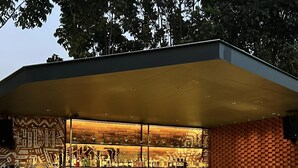 Un bar moderno con un diseño geométrico original y una amplia variedad de botellas a la vista.
