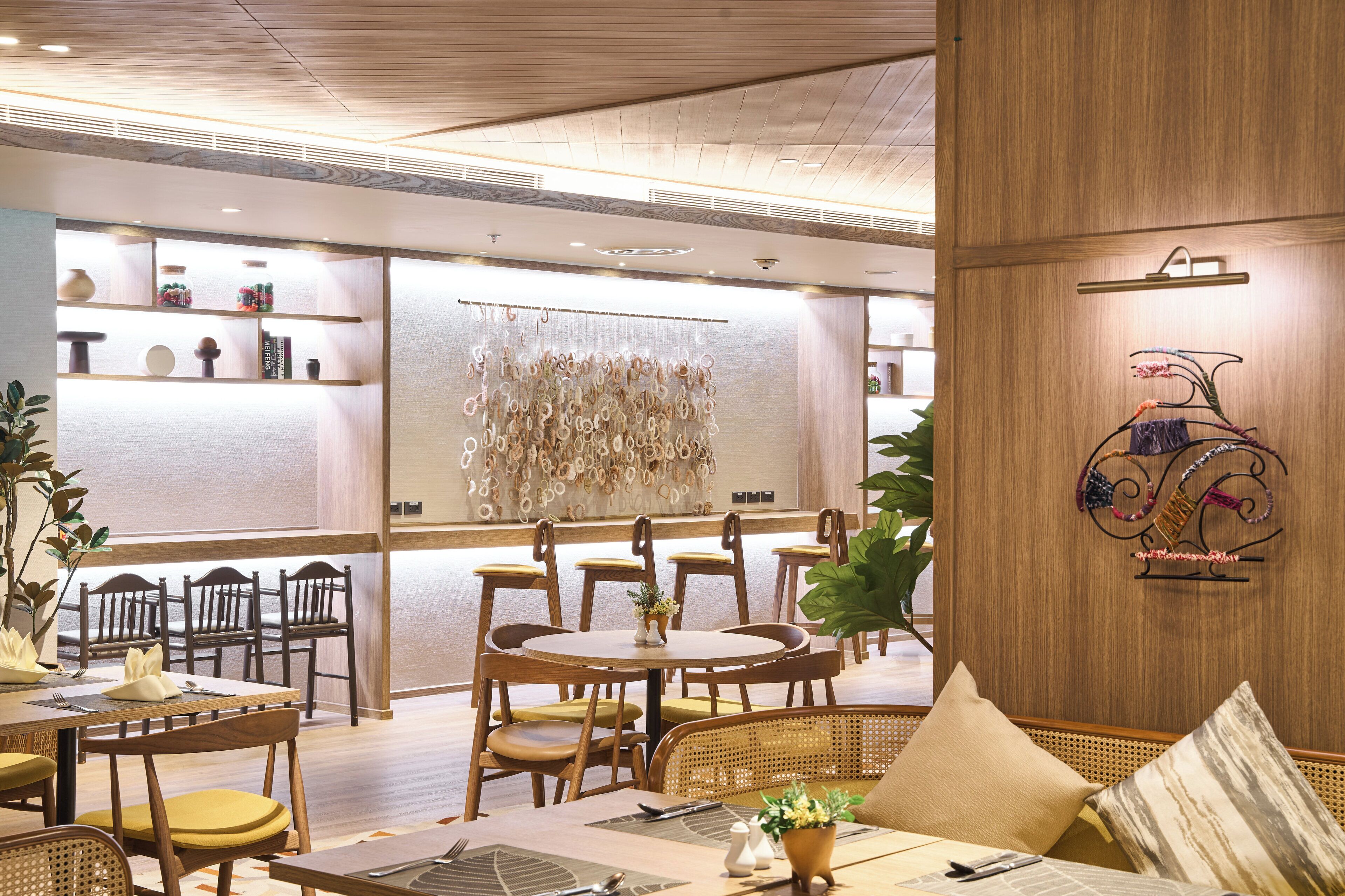 A restaurant with wooden furniture, a decorative wall, and a bicycle art piece.