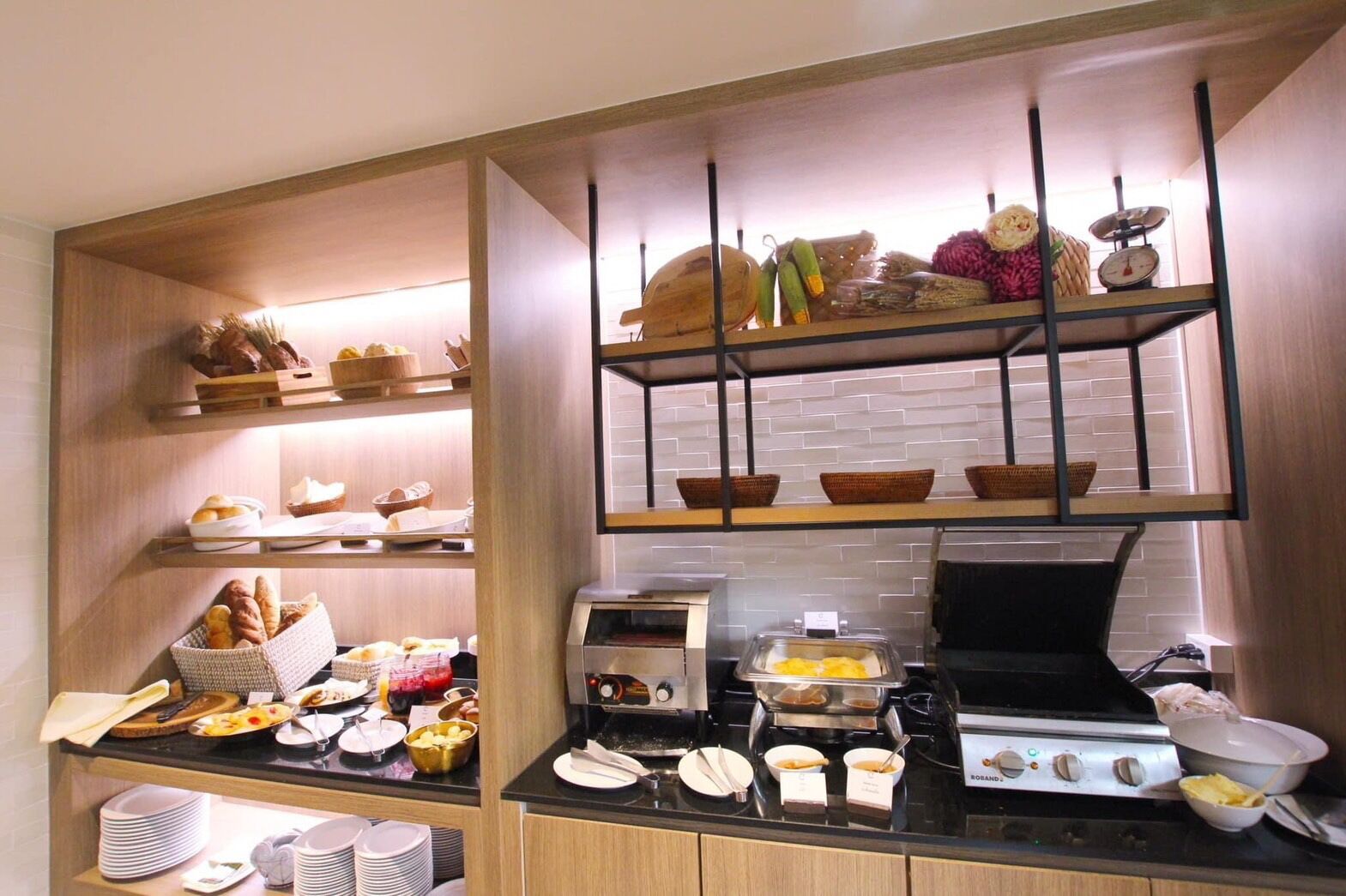 A kitchen with shelves stocked with bread, a toaster, and a stove.
