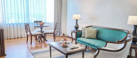 A living room with a sofa, chairs, a coffee table, and a side table with lamps.