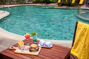 Una piscina al aire libre, sillones reclinables de piscina