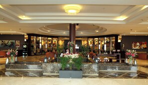A lobby with a central column, seating areas, and a reception desk. - Holiday Inn Al Khobar - Corniche by IHG (Al Khobar)