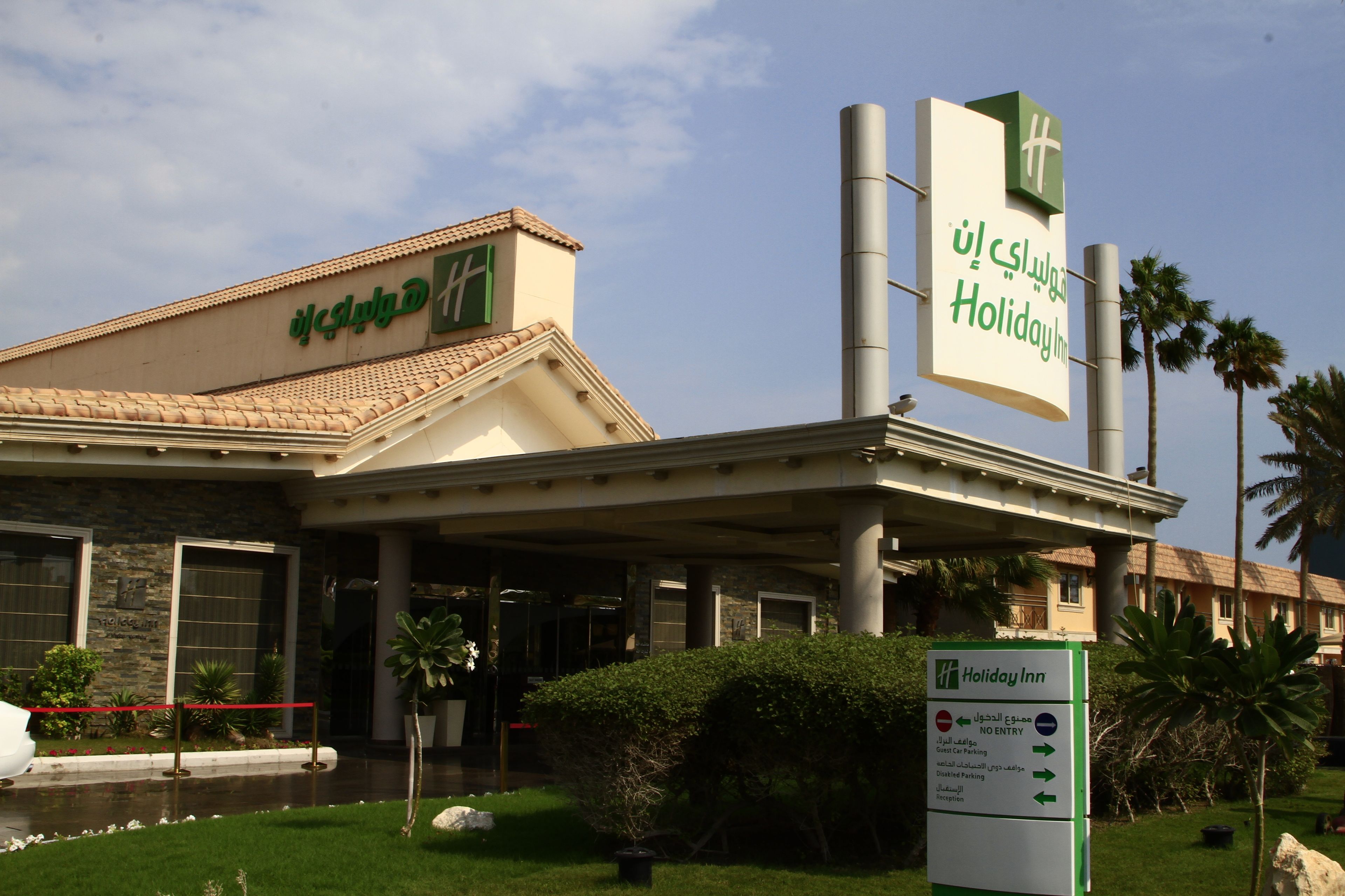 Un hôtel Holiday Inn avec un panneau indiquant qu’il est interdit aux voitures d’y entrer et des indications pour le stationnement des clients.