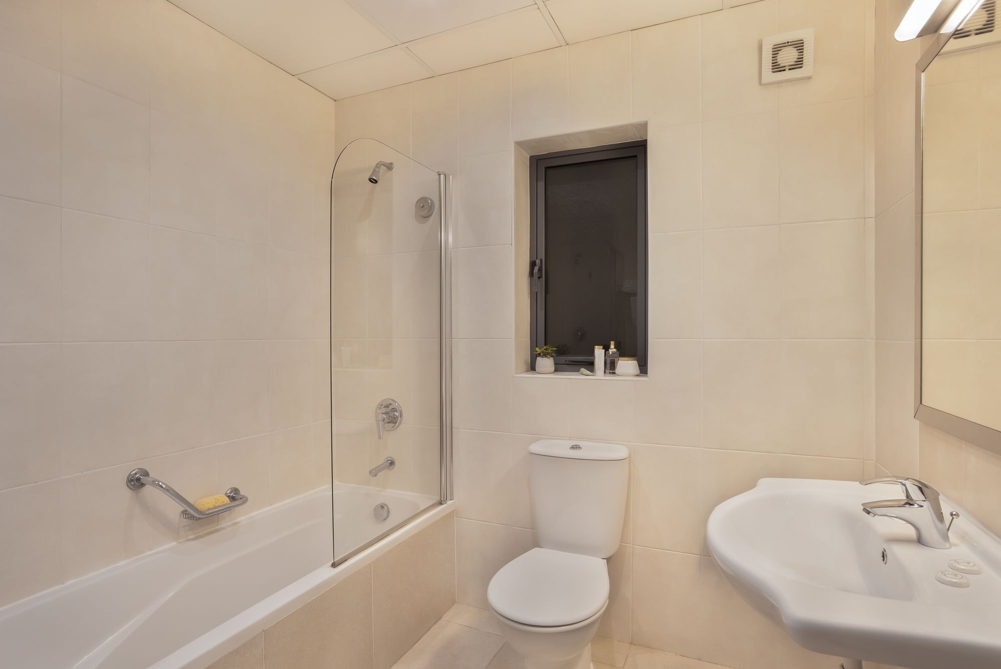 A bathroom with a bathtub, toilet, and sink.