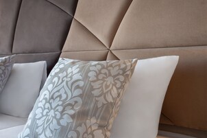 En del af en sofa med en pude med et mønster og en ensfarvet pude.