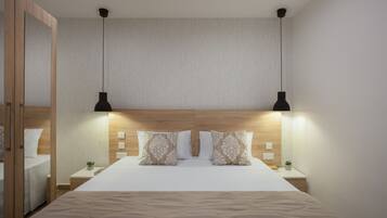 A neatly arranged bedroom with a large bed, two bedside tables, a wooden headboard, and two pendant lights.