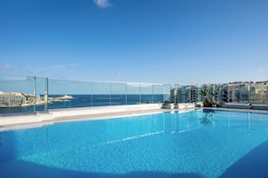 Una piscina techada, una piscina al aire libre de temporada, sombrillas