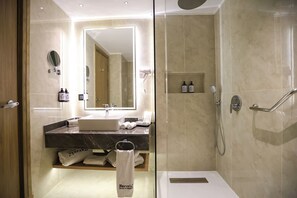 A modern bathroom with a glass shower enclosure, a vanity with a sink, and a large mirror. - Barceló Cairo Pyramids (Giza)
