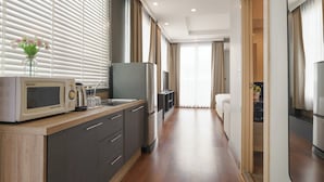 A modern kitchen with a microwave, kettle, and refrigerator. - iCheck inn Residence soi 2 (Bangkok)