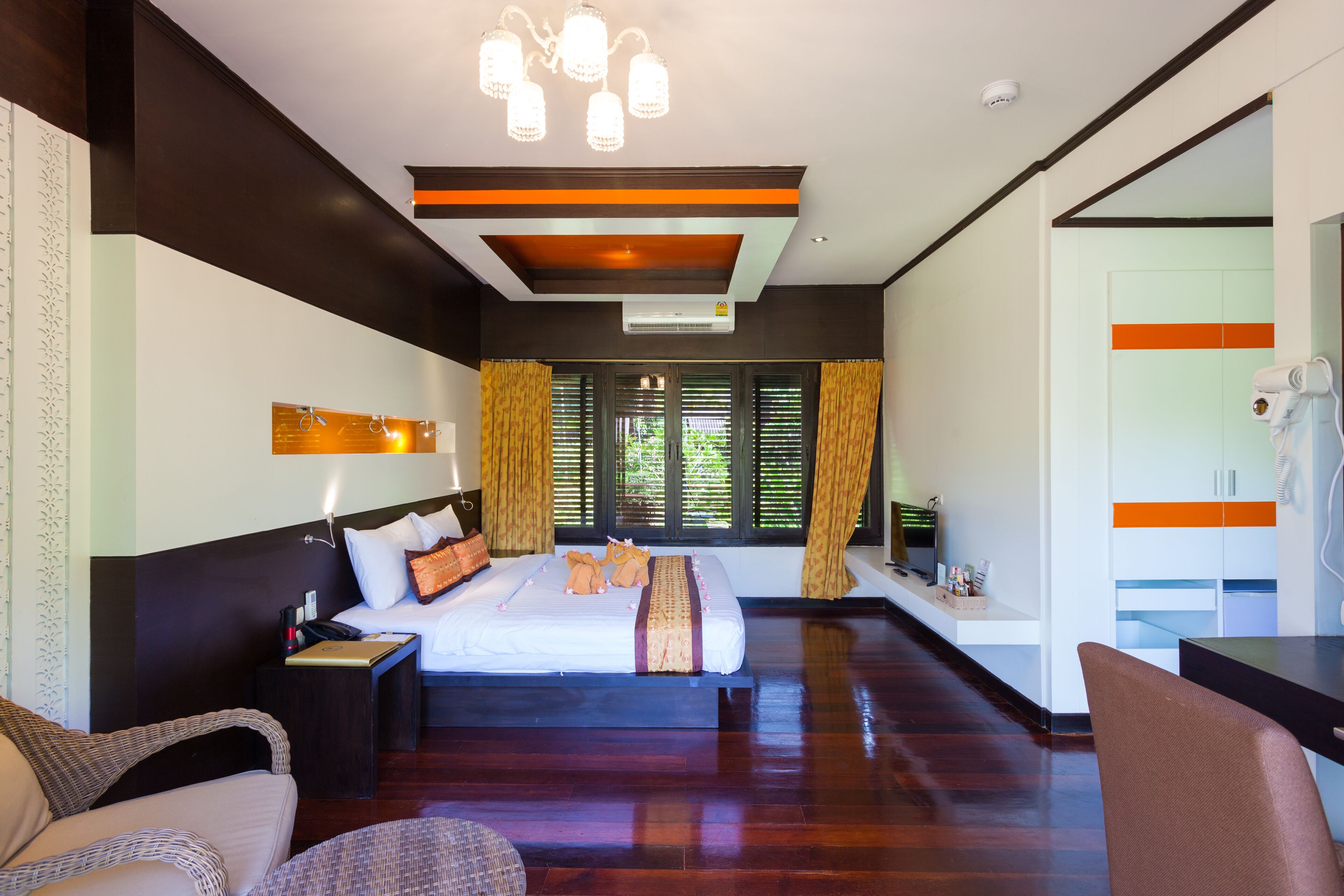 Habitación de hotel moderna con una cama grande, un escritorio y vistas al exterior.