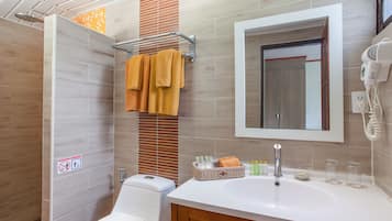 Une salle de bain moderne équipée d’une douche, de toilettes, d’un lavabo et d’un miroir.