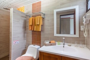 Un baño moderno con ducha, inodoro, lavabo y espejo.