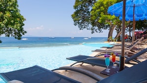 A poolside area with lounge chairs, a pool, and a view of the sea. - Phi Phi Natural Resort (Ko Phi Phi)
