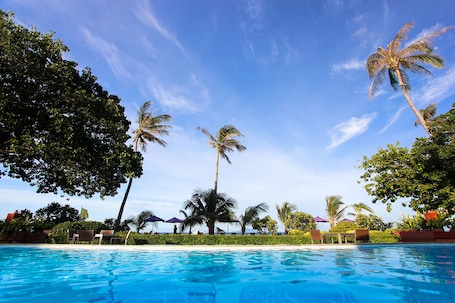 Una piscina al aire libre, sillones reclinables de piscina