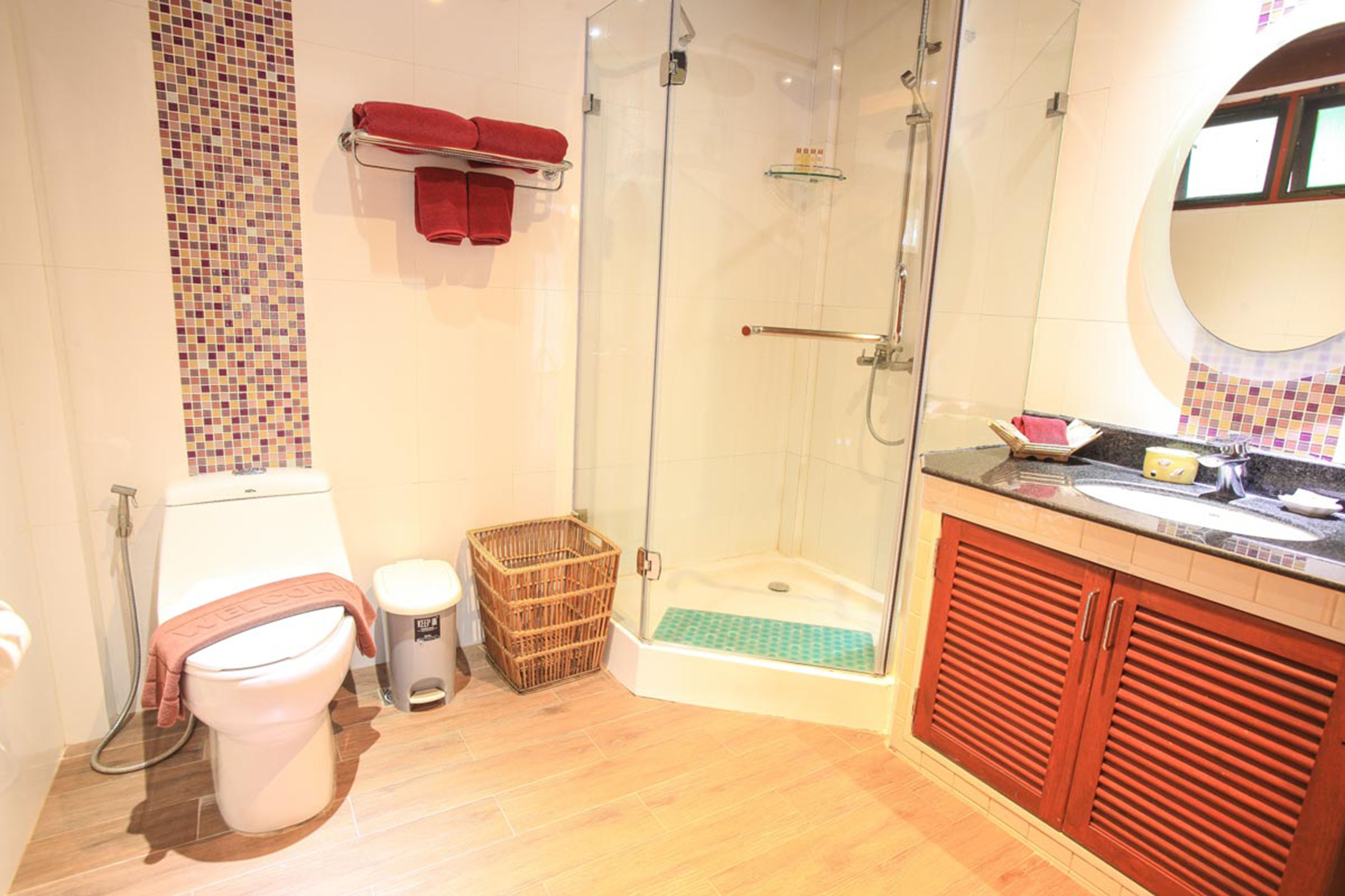 A bathroom with a toilet, shower, and sink.