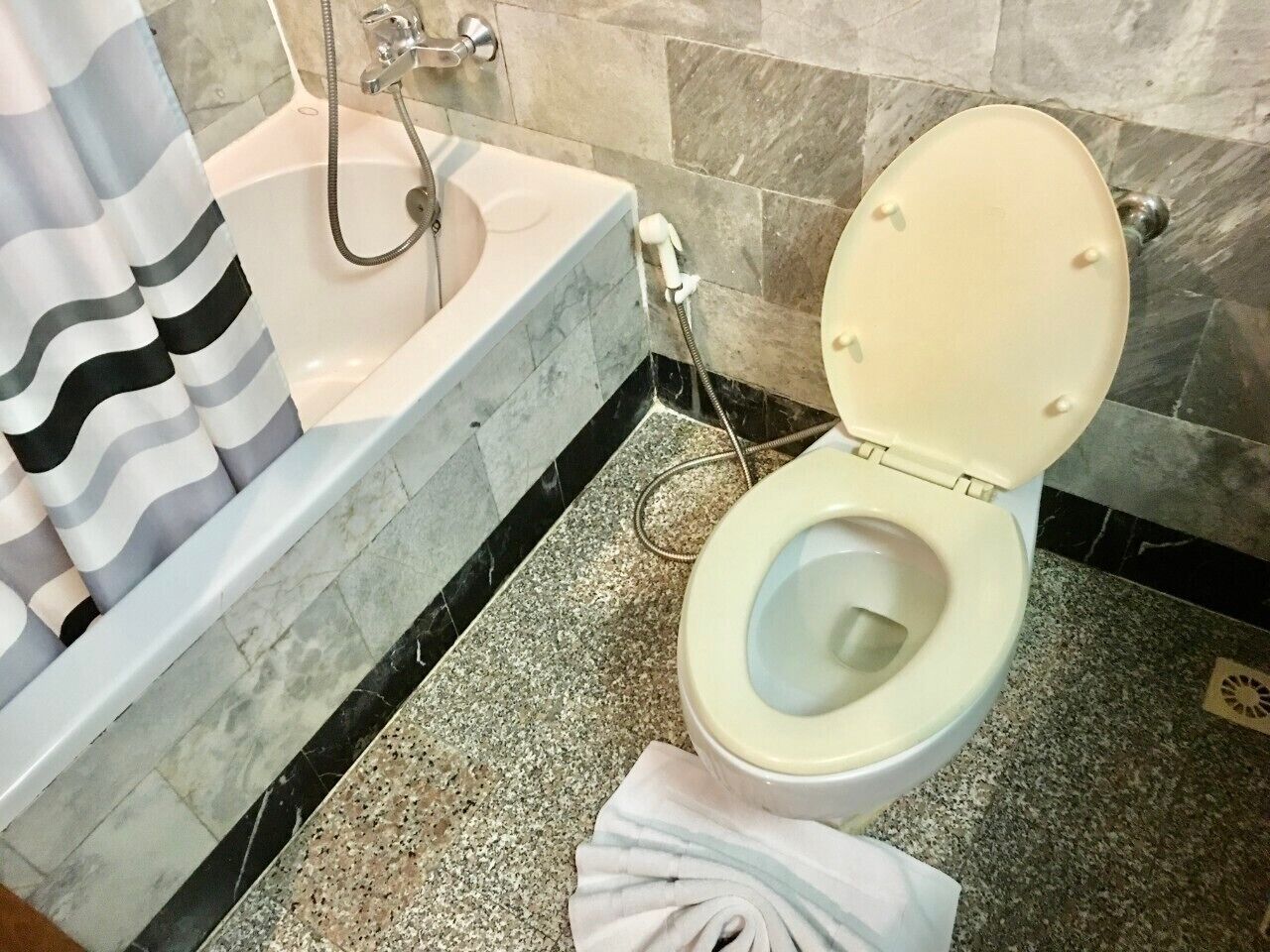 A bathroom with a bathtub, toilet, and a shower.